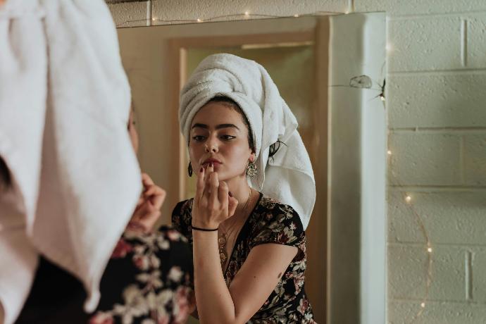 Afbeelding van een vrouw die haar gezicht verzorgt
