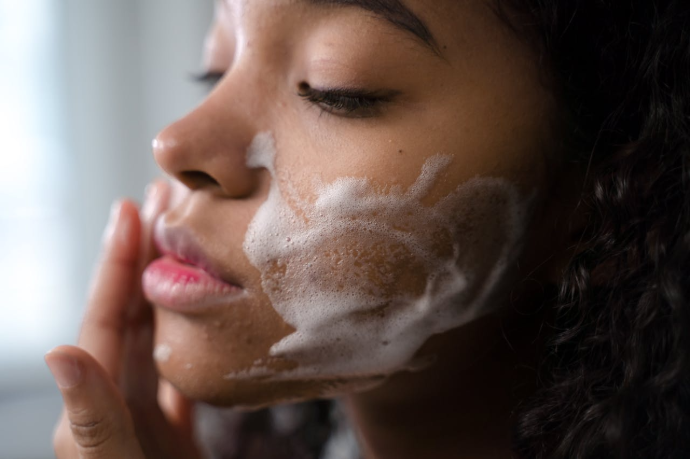 Visage de profil jeune femme noire avec de la mousse nettoyante sur la joue 