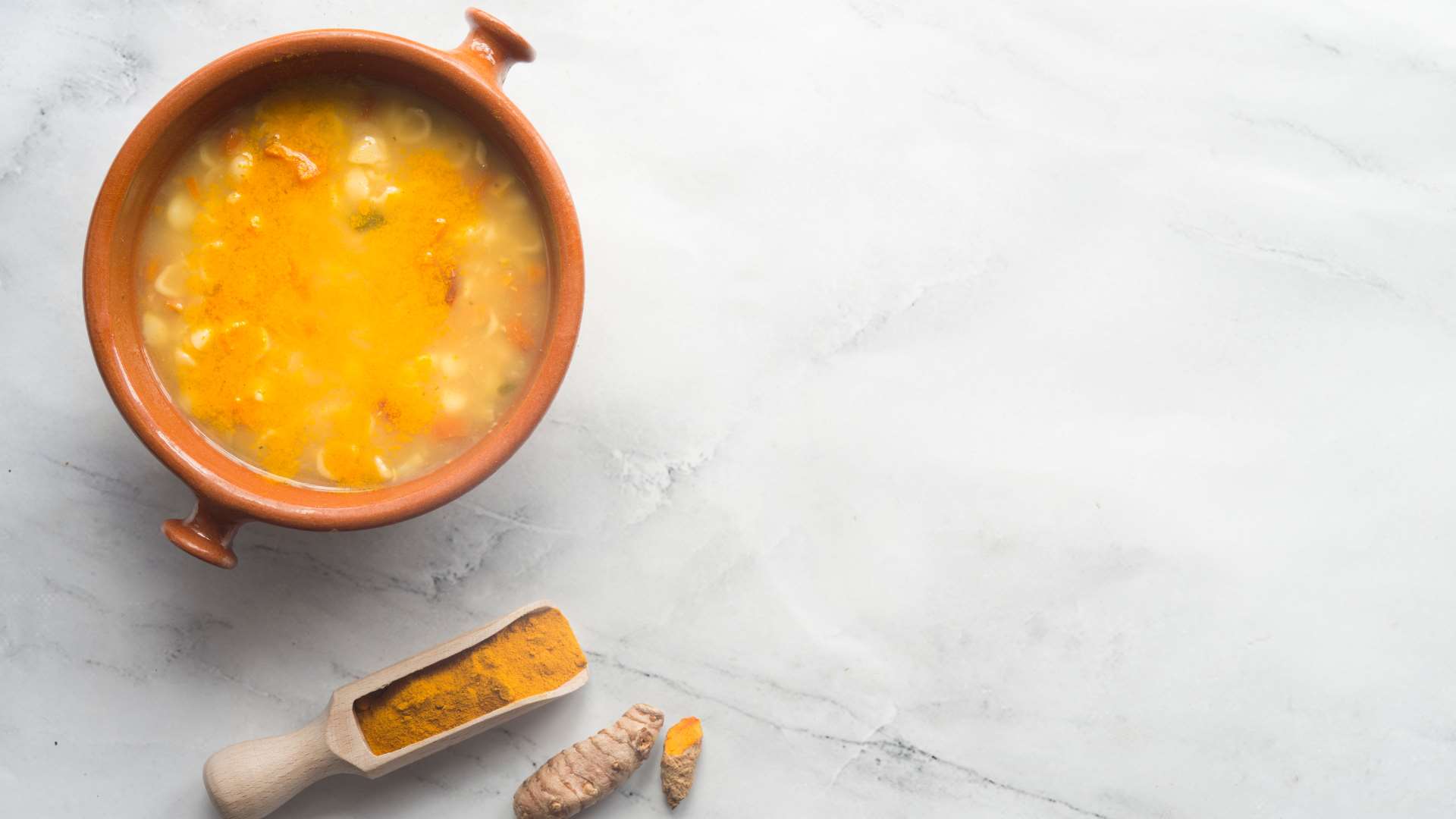 Orange soup with turmeric root and turmeric powder on the side