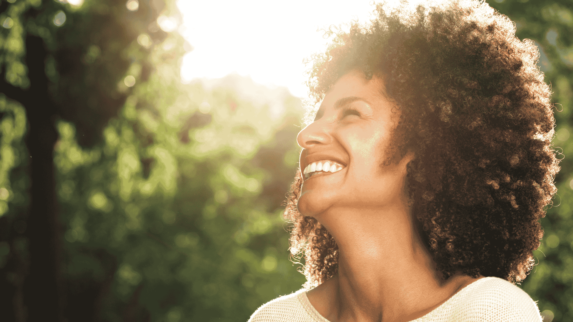 Femme métisse souriante avec soleil et arbre en arrière-plan