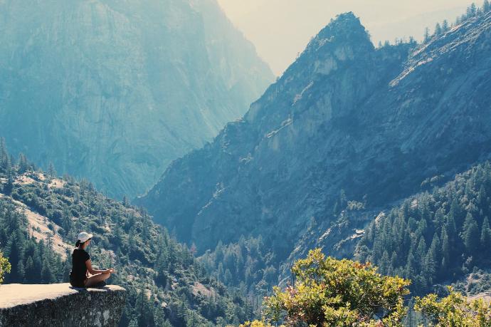 Femme qui médite face à des montagnes