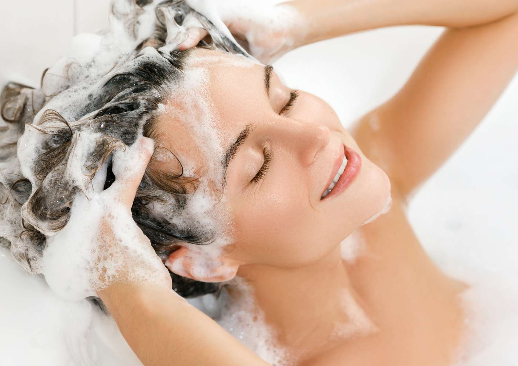 Femme détendue yeux fermés mais sur ses cheveux avec shampoing