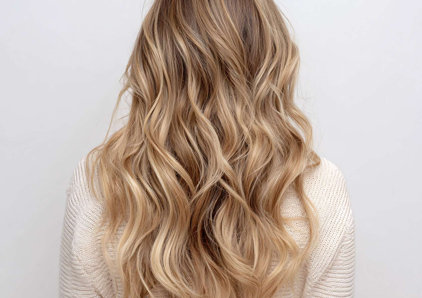 Cheveux blonds longs et ondulés femme de dos